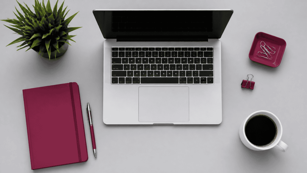 Modern workspace with laptop, notebook, and coffee on a clean desk.