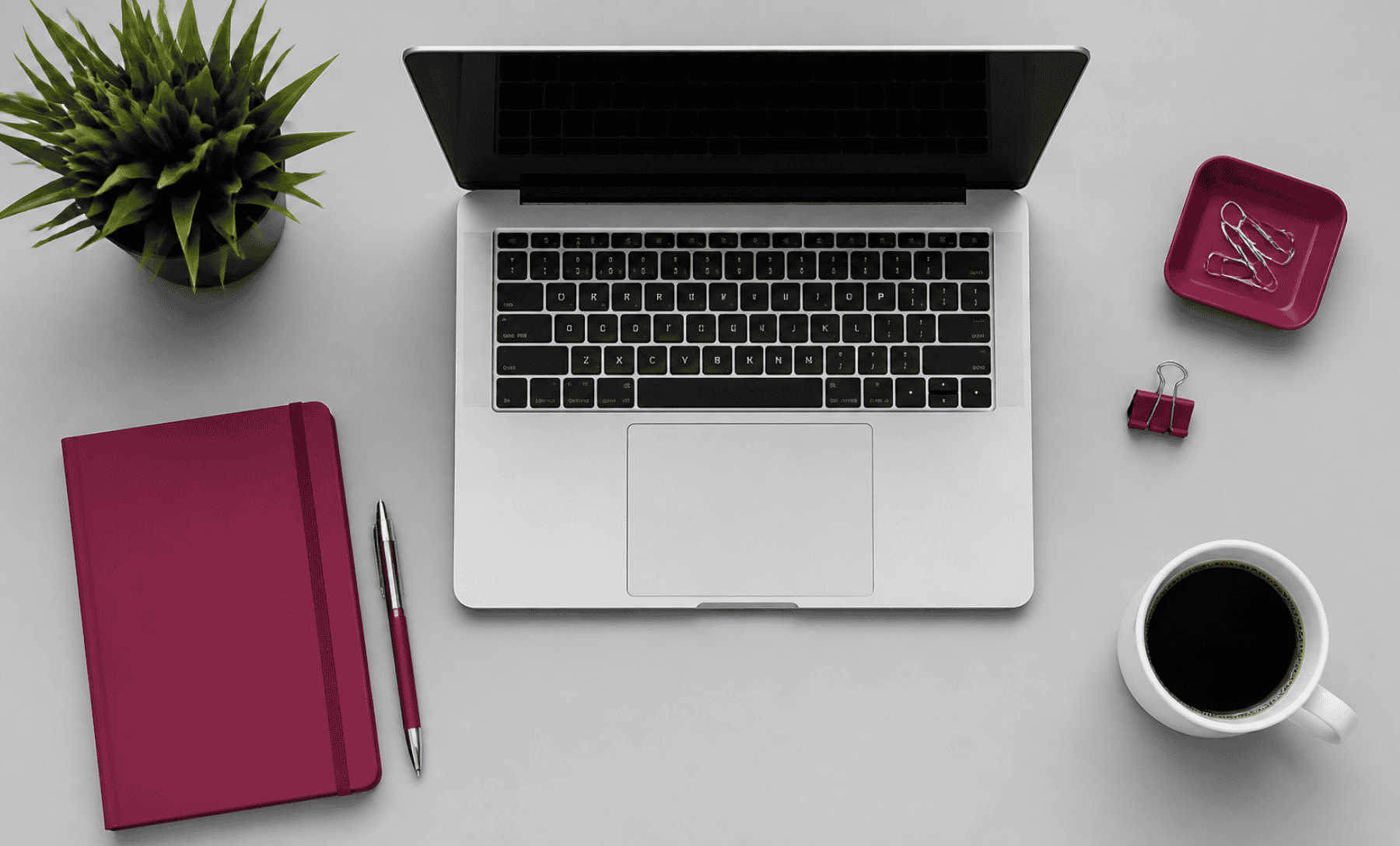 Modern workspace with laptop, notebook, and coffee on a clean desk.